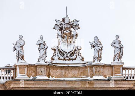 Snow-covered statues on the roof of St. Peter`s Cathedral in Vatican City in Rome in Italy. Stock Photo